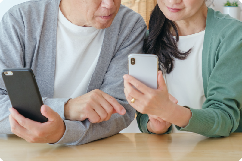 夫婦が携帯画面を覗き込みながら会話している様子