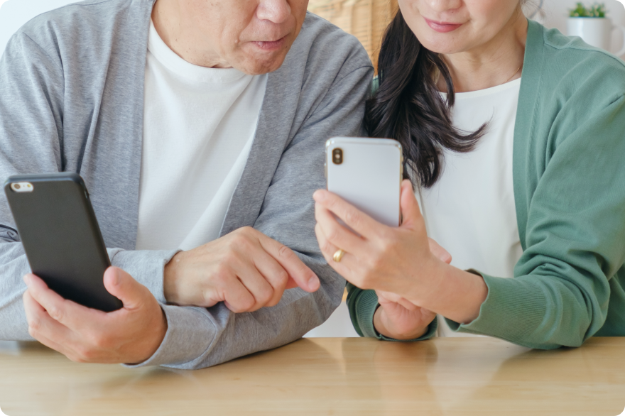 夫婦が携帯画面を覗き込みながら会話している様子