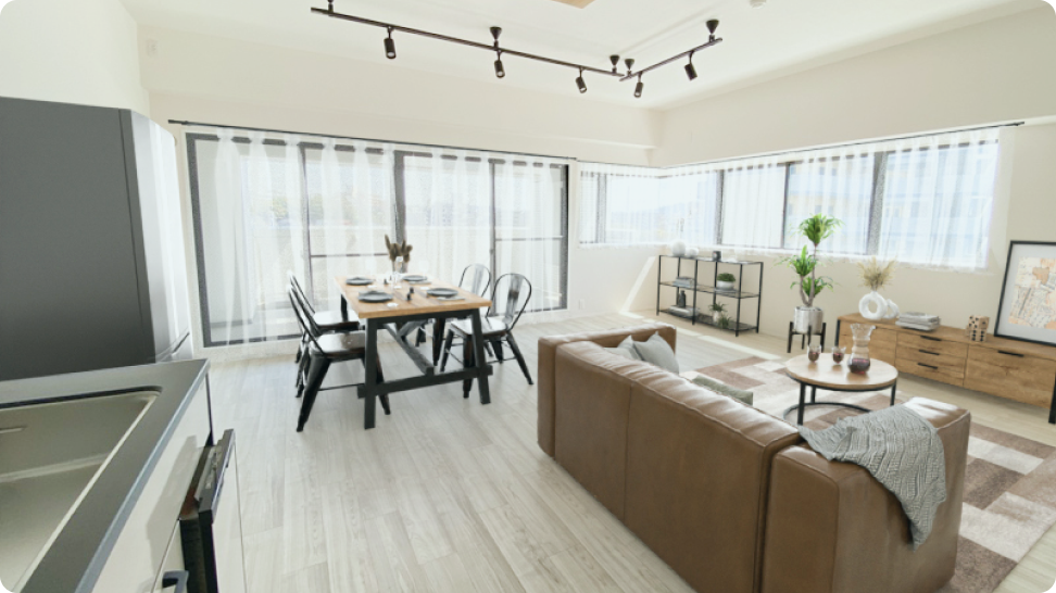大きな窓から光が差し込む広々としたLDK。グレー調の床にブラウンのレザーソファとモダンなダイニングテーブルを配置したマンションリノベーション事例